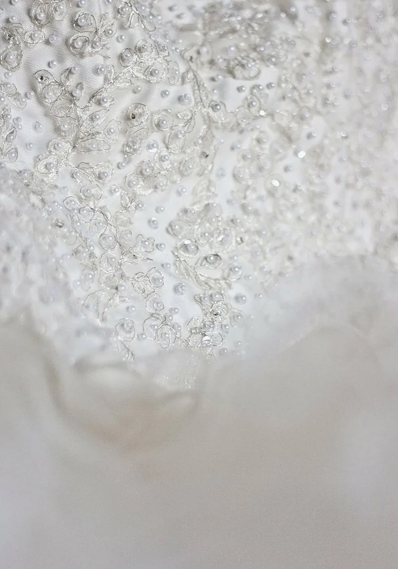 Close-up of white fabric with a scatter of small beads